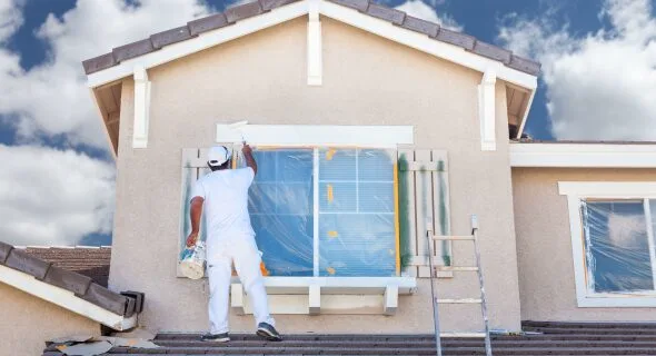 An AV Painting painter at work on a house