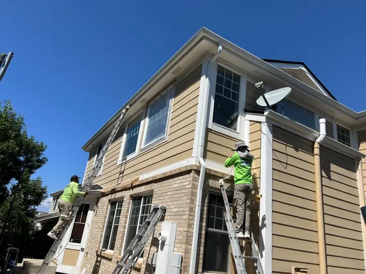 Paint Denver painters on ladders at a house